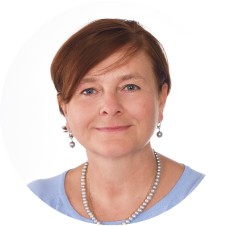 Nie wiem, kto jest na zdjęciu. Kobieta z krótkimi, brązowymi włosami, w naszyjniku i kolczykach, uśmiecha się na białym tle.